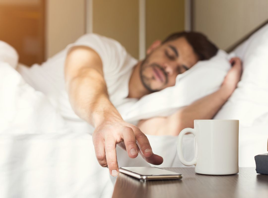 Wecker auf dem Nachttisch im Morgenlicht